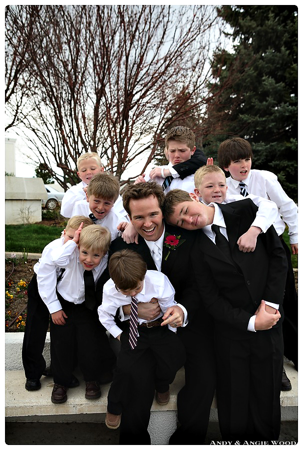 Groom wrestling with children at wedding