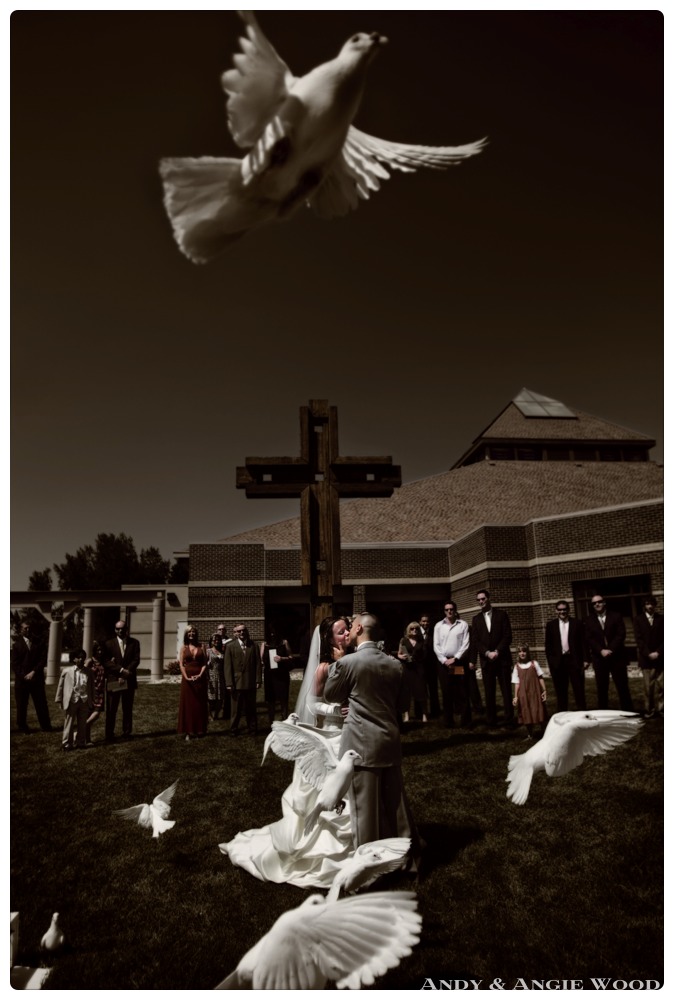 Bride and Groom kissing during dove release